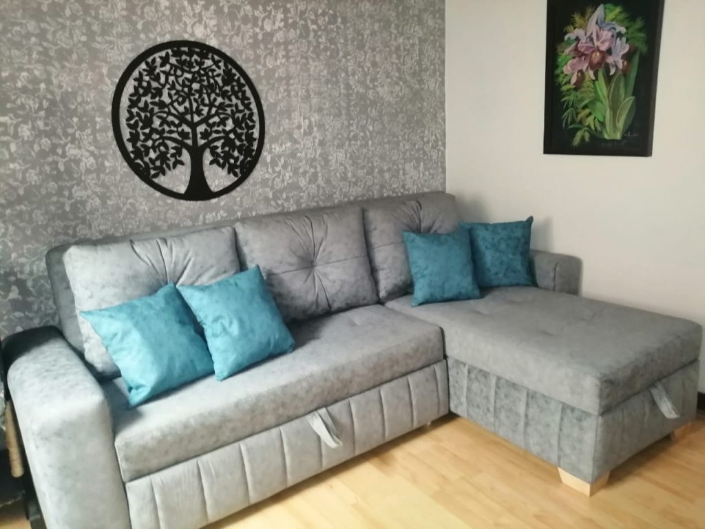Sofá seccional Kalapa gris con cojines teal