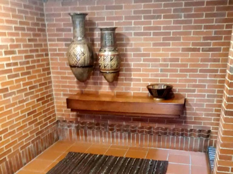 Mueble de madera Kalapa con diseño artesanal en pared de ladrillo